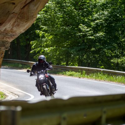 Bochtige bergweg in Luxemburg met overhangende rots – favoriete route tijdens motortourtocht